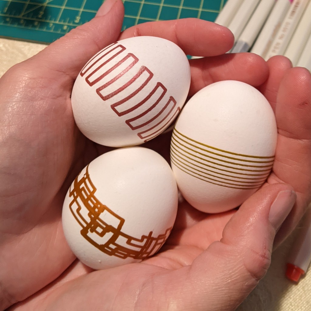 Eggs Decorated by Egg Deco Bot, held in hands.